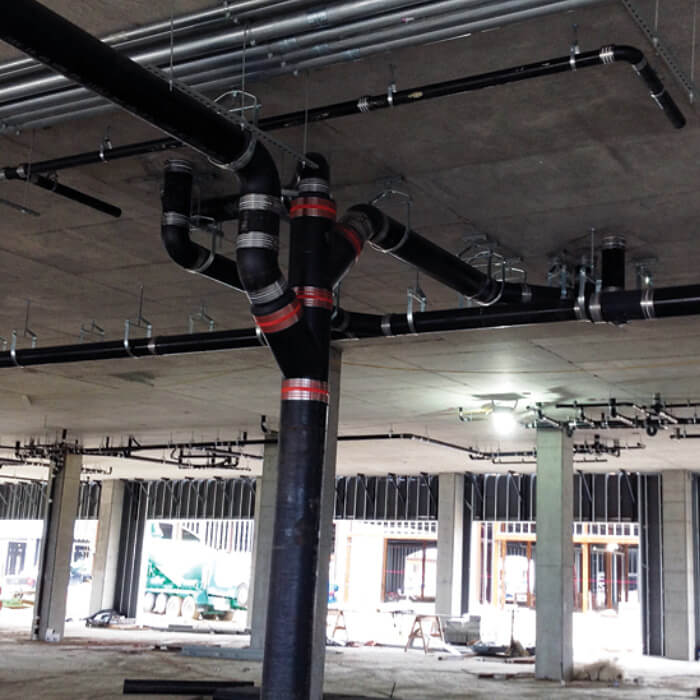 New cast iron drainage installation in an St. Albert parkade by Kingstree Plumbing's commercial plumbing team.