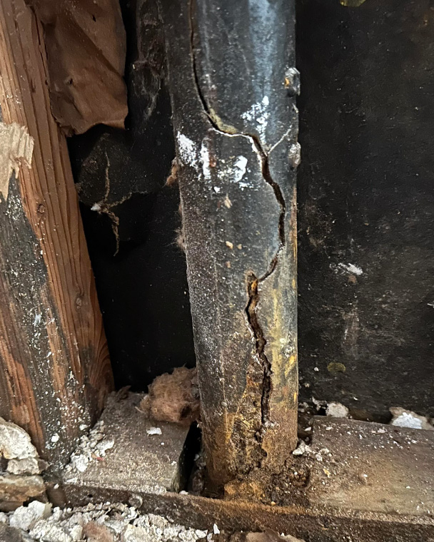 Cracked cast iron stack in an Canmore basement, set for Kingstree Plumbing's repair service.