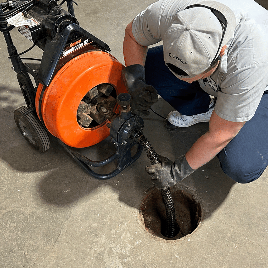 Dane expertly augering a floor drain in Sherwood Park, as part of our comprehensive drain cleaning services.