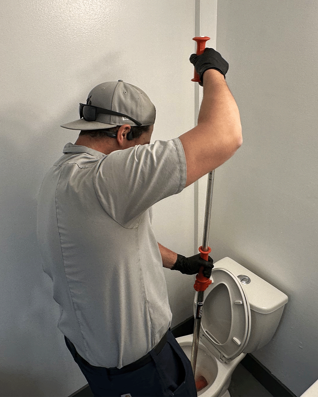 Dane augering a toilet in St. Albert, an important procedure in our drain cleaning services.