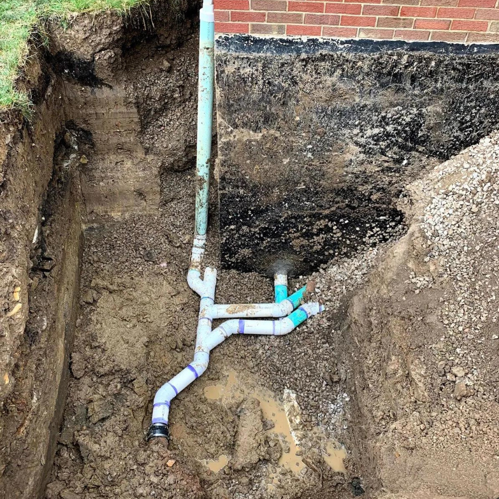 Exposed storm and sanitary drains in an Canmore trench, prepared for sewer line repair.