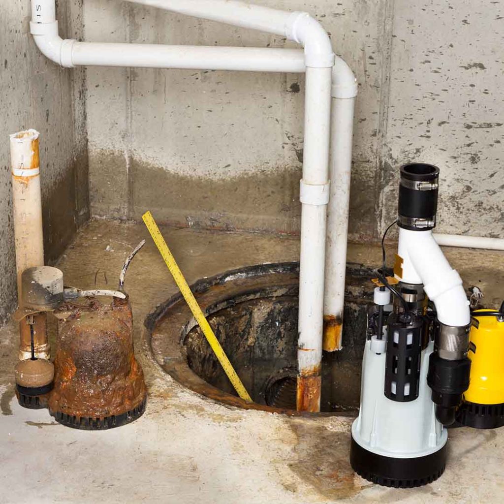 New sump pump beside old worn-out unit during replacement in Sherwood Park